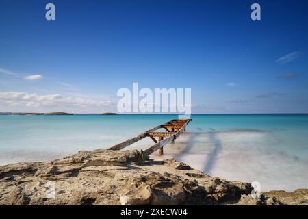 Il vecchio molo conduce alle acque turchesi della spiaggia di Ses Illetes nel nord di Formentera Foto Stock