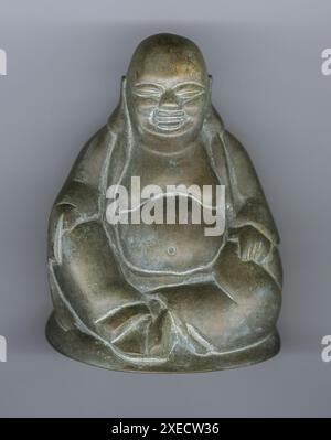 Una piccola statuetta in metallo del profeta o Buddha dietetico sullo sfondo bianco dello studio. Foto Stock