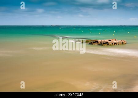 Fotografia a lunga esposizione che cattura i resti di Mulberry B a Gold Beach ad Arromanches, in Normandia. Splendide acque turchesi e spiaggia di sabbia dorata Foto Stock