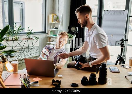 Due uomini amorevoli davanti al portatile, concentrati sul lavoro. Foto Stock