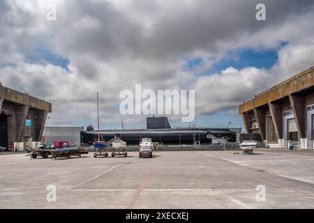 Base sottomarina tedesca della seconda guerra mondiale a Lorient, Bretagna, Francia, con un sottomarino francese degli anni '1960 attraccato tra grandi strutture in cemento. Foto Stock