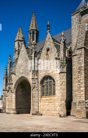 Vista della storica Collegiale Saint Aubin a Guerande, Francia, che mostra la sua splendida architettura in pietra e i dettagli intricati su un blu chiaro Foto Stock