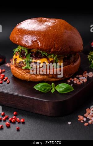 Hamburger con succosa cotoletta di manzo, formaggio, pomodori, sale, spezie ed erbe aromatiche Foto Stock