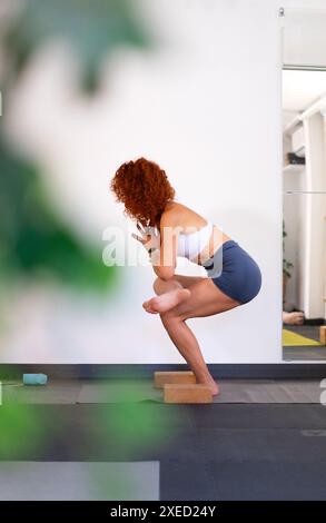 Istruttrice di yoga messicana di mezza età che fa una posa di yoga nella sua classe di yoga Foto Stock