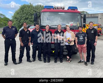 Foto di Alice Hearle e Josh Beardmore con la loro bambina Olive, nata nel retro di un'auto alle 14:36 del 16 maggio, riunita con i vigili del fuoco Rosie Tonkin (quarta da sinistra) e Katie Hoskins (con Olivia) con i loro colleghi del Cornwall Fire and Rescue Service che hanno contribuito a portare Olivia nel mondo. Data di pubblicazione: Giovedì 27 giugno 2024. Foto Stock