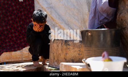 11 giugno 2024, Sarmada, Governatorato di Idlib, Siria: Sarmada, Idlib, Siria. 11 giugno 2024. Un bambino siriano sfollato fuori da una tenda nel campo di Tell al-Fakhar nel nord-ovest della Siria. Tell al-Fakhar è uno dei campi di sfollati interni (IDP) vicino a Sarmada, nel governatorato di Idlib. I residenti del campo di Tell al-Fakhar vivono in tende usurate per 6 anni dopo essere stati sfollati dalle loro case a seguito di scioperi effettuati dalle forze governative siriane (immagine di credito: © Hussein Ali/IMAGESLIVE via ZUMA Press Wire) SOLO PER USO EDITORIALE! Non per USO commerciale! Foto Stock