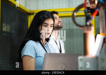 Uomo d'affari dell'ispezione e del collaudo del braccio robotizzato per l'uso in industrie manifatturiere complesse su larga scala. Foto Stock