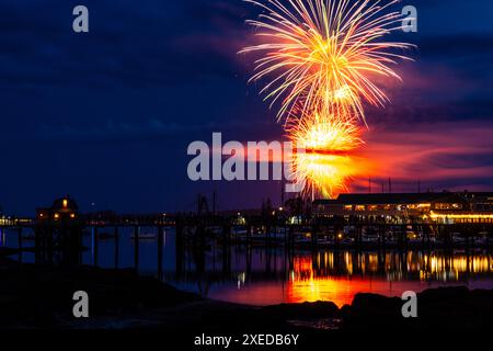 Boothbay Harbor, Stati Uniti. 26 giugno 2024. I fuochi d'artificio esplodono nel cielo sopra il porto e lo storico lungomare durante l'annuale festival Windjammer Days, 26 giugno 2024, a Boothbay Harbor, Maine. Windjammer Days, iniziato nel 1962, inizia la stagione estiva nella regione costiera. Crediti: Richard Ellis/Richard Ellis/Alamy Live News Foto Stock