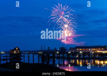 Boothbay Harbor, Stati Uniti. 26 giugno 2024. I fuochi d'artificio esplodono nel cielo sopra il porto e lo storico lungomare durante l'annuale festival Windjammer Days, 26 giugno 2024, a Boothbay Harbor, Maine. Windjammer Days, iniziato nel 1962, inizia la stagione estiva nella regione costiera. Crediti: Richard Ellis/Richard Ellis/Alamy Live News Foto Stock