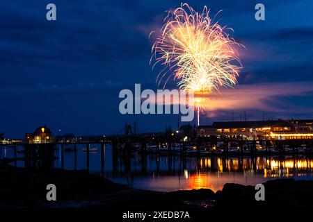 Boothbay Harbor, Stati Uniti. 26 giugno 2024. I fuochi d'artificio esplodono nel cielo sopra il porto e lo storico lungomare durante l'annuale festival Windjammer Days, 26 giugno 2024, a Boothbay Harbor, Maine. Windjammer Days, iniziato nel 1962, inizia la stagione estiva nella regione costiera. Crediti: Richard Ellis/Richard Ellis/Alamy Live News Foto Stock