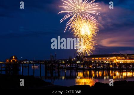 Boothbay Harbor, Stati Uniti. 26 giugno 2024. I fuochi d'artificio esplodono nel cielo sopra il porto e lo storico lungomare durante l'annuale festival Windjammer Days, 26 giugno 2024, a Boothbay Harbor, Maine. Windjammer Days, iniziato nel 1962, inizia la stagione estiva nella regione costiera. Crediti: Richard Ellis/Richard Ellis/Alamy Live News Foto Stock