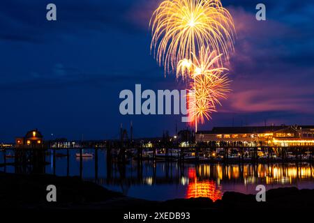 Boothbay Harbor, Stati Uniti. 26 giugno 2024. I fuochi d'artificio esplodono nel cielo sopra il porto e lo storico lungomare durante l'annuale festival Windjammer Days, 26 giugno 2024, a Boothbay Harbor, Maine. Windjammer Days, iniziato nel 1962, inizia la stagione estiva nella regione costiera. Crediti: Richard Ellis/Richard Ellis/Alamy Live News Foto Stock