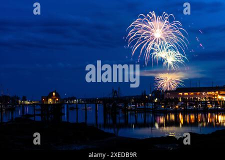 Boothbay Harbor, Stati Uniti. 26 giugno 2024. I fuochi d'artificio esplodono nel cielo sopra il porto e lo storico lungomare durante l'annuale festival Windjammer Days, 26 giugno 2024, a Boothbay Harbor, Maine. Windjammer Days, iniziato nel 1962, inizia la stagione estiva nella regione costiera. Crediti: Richard Ellis/Richard Ellis/Alamy Live News Foto Stock