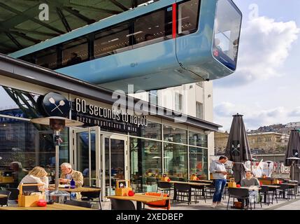 Ferrovia sospesa sopra la zona pranzo all'aperto della stazione centrale, Wuppertal, Germania, Europa Foto Stock