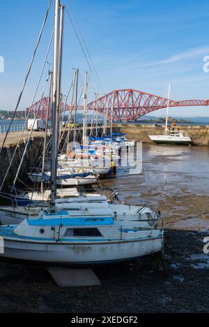 South Queensferry, Scozia, Regno Unito, porto con barche a vela con bassa marea e Forth Bridge sull'estuario del fiume Firth of Forth. Foto Stock