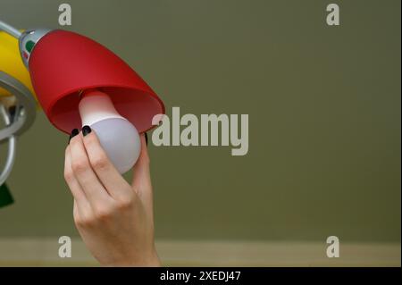 Una lampadina a LED in mano a una donna Foto Stock