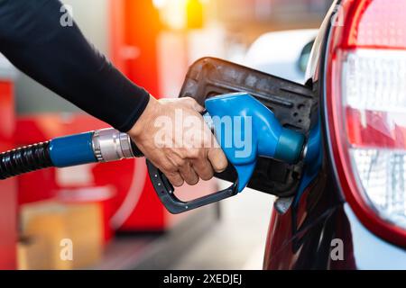 Il rifornimento di carburante della macchina in corrispondenza di una stazione di rifornimento della pompa del combustibile. Man mano driver di riempimento e di pompaggio olio di benzina la vettura con il carburante alla stazione di rifornimento. Il rifornimento di carburante per auto Foto Stock