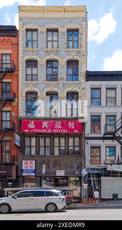 NYC Chinatown: 101 Bowery, costruito nel 1875, presenta quoin di pietra e finestre intorno ai suoi piani superiori; classificato come un hotel SRO (camera singola). Foto Stock