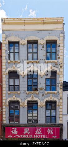 NYC Chinatown: 101 Bowery, costruito nel 1875, presenta quoin di pietra e finestre intorno ai suoi piani superiori; classificato come un hotel SRO (camera singola). Foto Stock