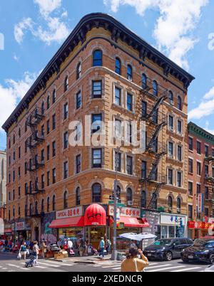 NYC Chinatown: 116 Mott Street, un edificio di appartamenti a sei piani, con un angolo arrotondato e dettagli in terracotta bianca sulla sua facciata in mattoni arancioni. Foto Stock