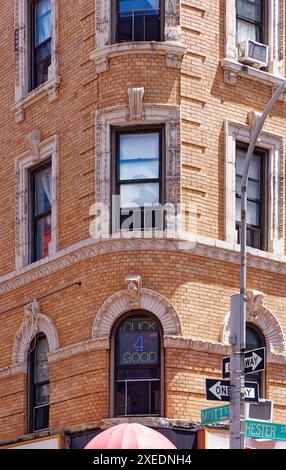 NYC Chinatown: 116 Mott Street, un edificio di appartamenti a sei piani, con un angolo arrotondato e dettagli in terracotta bianca sulla sua facciata in mattoni arancioni. Foto Stock