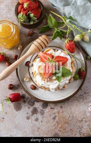 Waffle belgi con fragole fresche di frutti di bosco e ricotta per colazione su sfondo sasso. Foto Stock