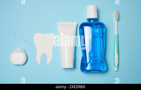 Collutorio, tubo per dentifricio, filo interdentale su sfondo blu, igiene orale Foto Stock