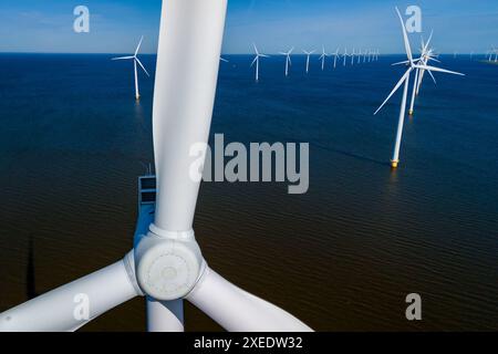 Parco eolico nell'oceano, con file di eleganti turbine eoliche alte nei Paesi Bassi Foto Stock