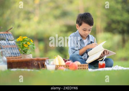 Famiglia felice che si diverte a fare un picnic nel parco, sedersi e leggere libri. Foto Stock