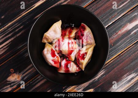 Gnocchi ripieni di ciliegia su piatto nero Foto Stock