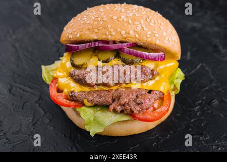 Doppio hamburger di polpette con sottaceti su pietra nera Foto Stock