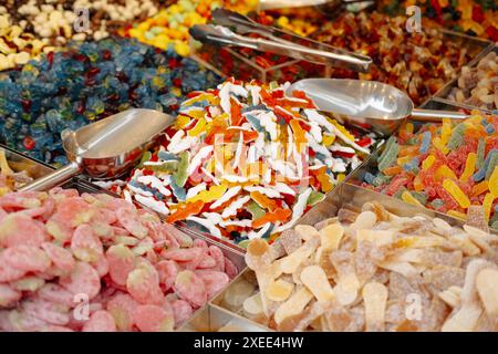 Un primo piano presenta una selezione diversificata di caramelle colorate in un mercato, catturandone la varietà e la vivacità Foto Stock