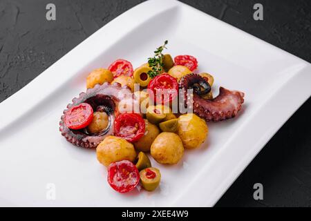 Insalata di polpo fresca con patate e olive sul piatto Foto Stock