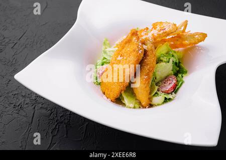 Pepite di pollo con insalata di verdure sul piatto Foto Stock
