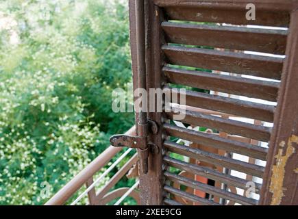 Vecchia tapparella in legno sul balcone con vista sugli alberi, Salonicco, Grecia Foto Stock