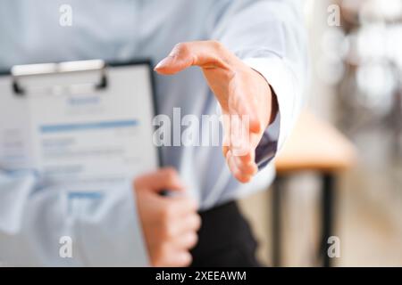 La mano di un uomo d'affari è stata tesa per una stretta di mano, segnalando la disponibilità a impegnarsi. Foto Stock