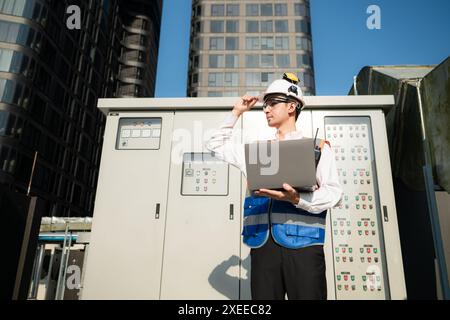 Prima di procedere con il test, l'ingegnere elettrico ispeziona il pannello di controllo installato. Foto Stock