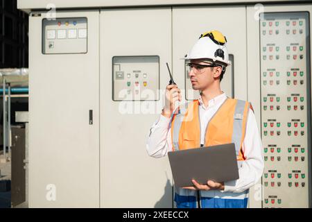 Prima di procedere con il test, l'ingegnere elettrico ispeziona il pannello di controllo installato. Foto Stock