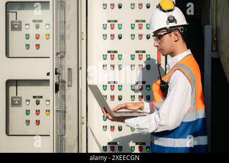 Prima di procedere con il test, l'ingegnere elettrico ispeziona il pannello di controllo installato. Foto Stock