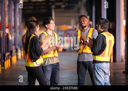 Un gruppo di dipendenti del magazzino che ispezionano i prodotti sugli scaffali del magazzino prima di essere inviati al rivenditore Foto Stock