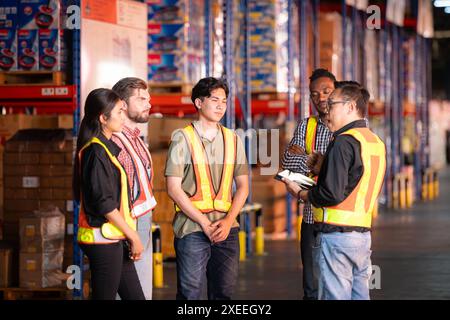 Un gruppo di dipendenti del magazzino che ispezionano i prodotti sugli scaffali del magazzino prima di essere inviati al rivenditore Foto Stock