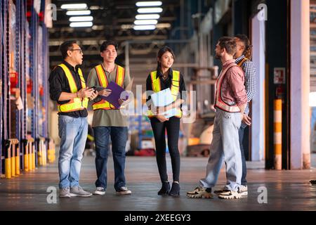 Un gruppo di dipendenti del magazzino che ispezionano i prodotti sugli scaffali del magazzino prima di essere inviati al rivenditore Foto Stock
