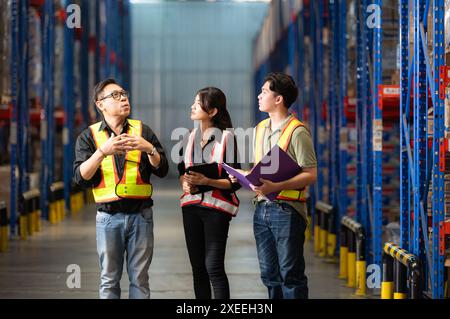 Un gruppo di dipendenti del magazzino che ispezionano i prodotti sugli scaffali del magazzino prima di essere inviati al rivenditore Foto Stock