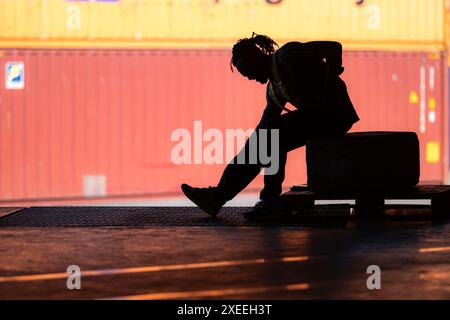 Il mal di schiena del magazziniere dovuto al duro lavoro mentre si è seduti e rilassati, concetto di silhouette Foto Stock