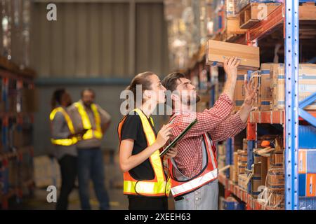 Un gruppo di dipendenti del magazzino che ispezionano i prodotti sugli scaffali del magazzino prima di essere inviati al rivenditore Foto Stock
