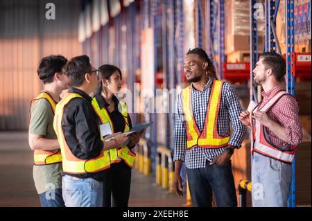 Un gruppo di dipendenti del magazzino che ispezionano i prodotti sugli scaffali del magazzino prima di essere inviati al rivenditore Foto Stock