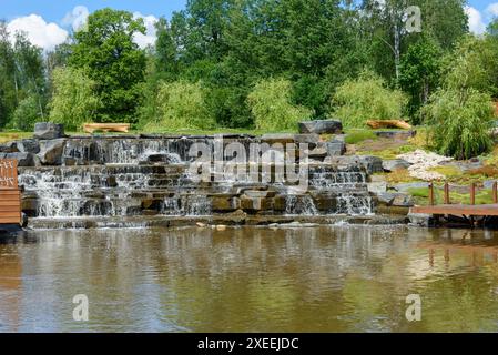 L'acqua scorre lungo i gradini di pietra in una cascata nel parco. Entra nel parco. Foto Stock