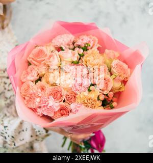 Bouquet rosa in mano della donna Foto Stock