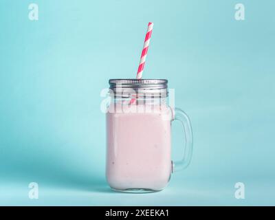 Frullato di fragola in vetro vaso di murino su blu Foto Stock