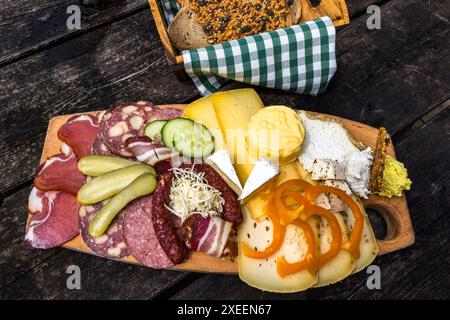 Un vassoio di snack della Filzmoosalm nella valle di Großarl, Salisburgo, Austria, visto dall'alto, presenta formaggio acido, Camembert, burro, formaggio a pasta dura, pancetta, prosciutto e salsiccia con pane fresco – tutto di produzione propria dell'alm. Foto Stock